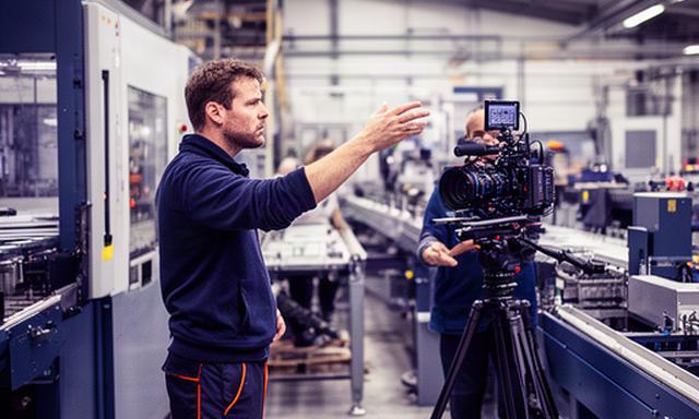 Manufacturing engineer reviewing a production line with a camera crew in Leicestershire