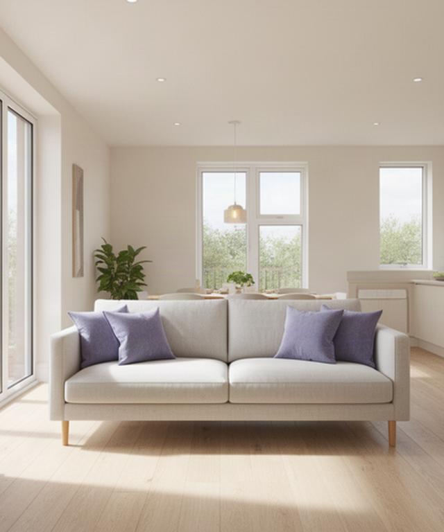 Sunlit modern apartment interior with a pale sofa and large windows in Leicester